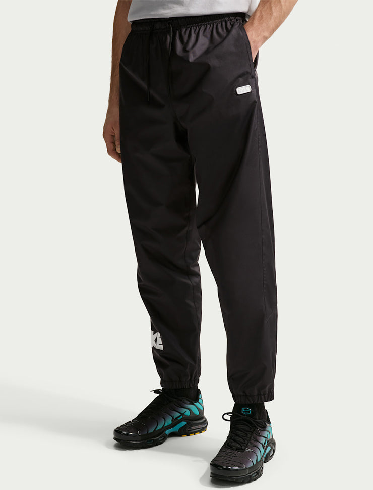 Pantaloni in tessuto con grafica Nike Windrunner IF0842-010 Black/(White) Uomo